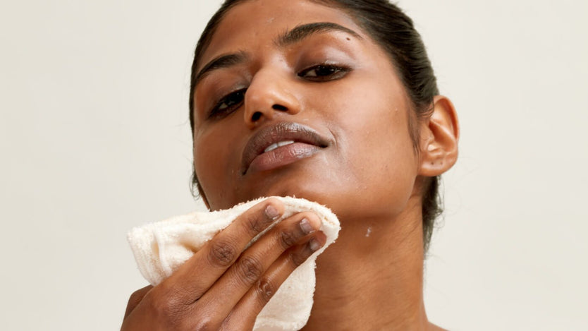 woman wiping off face mask with cloth